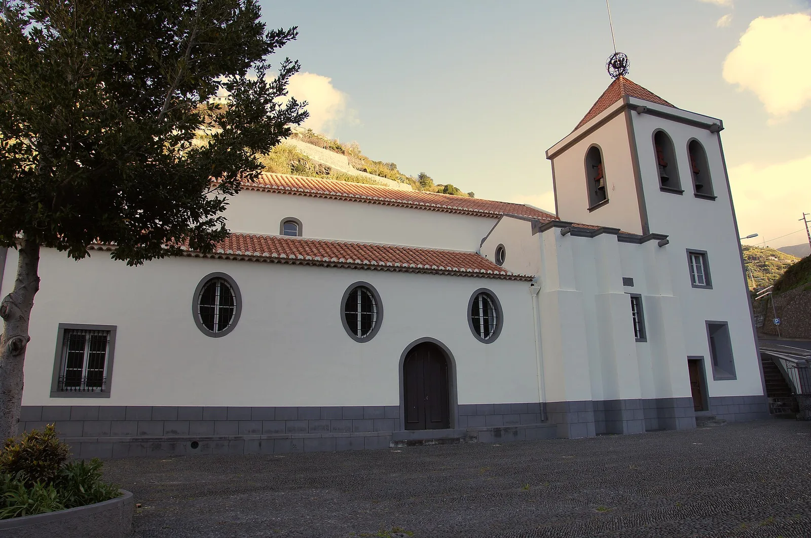 The white façade and basalt trim of the parish church of the Holy Spirit in Calheta