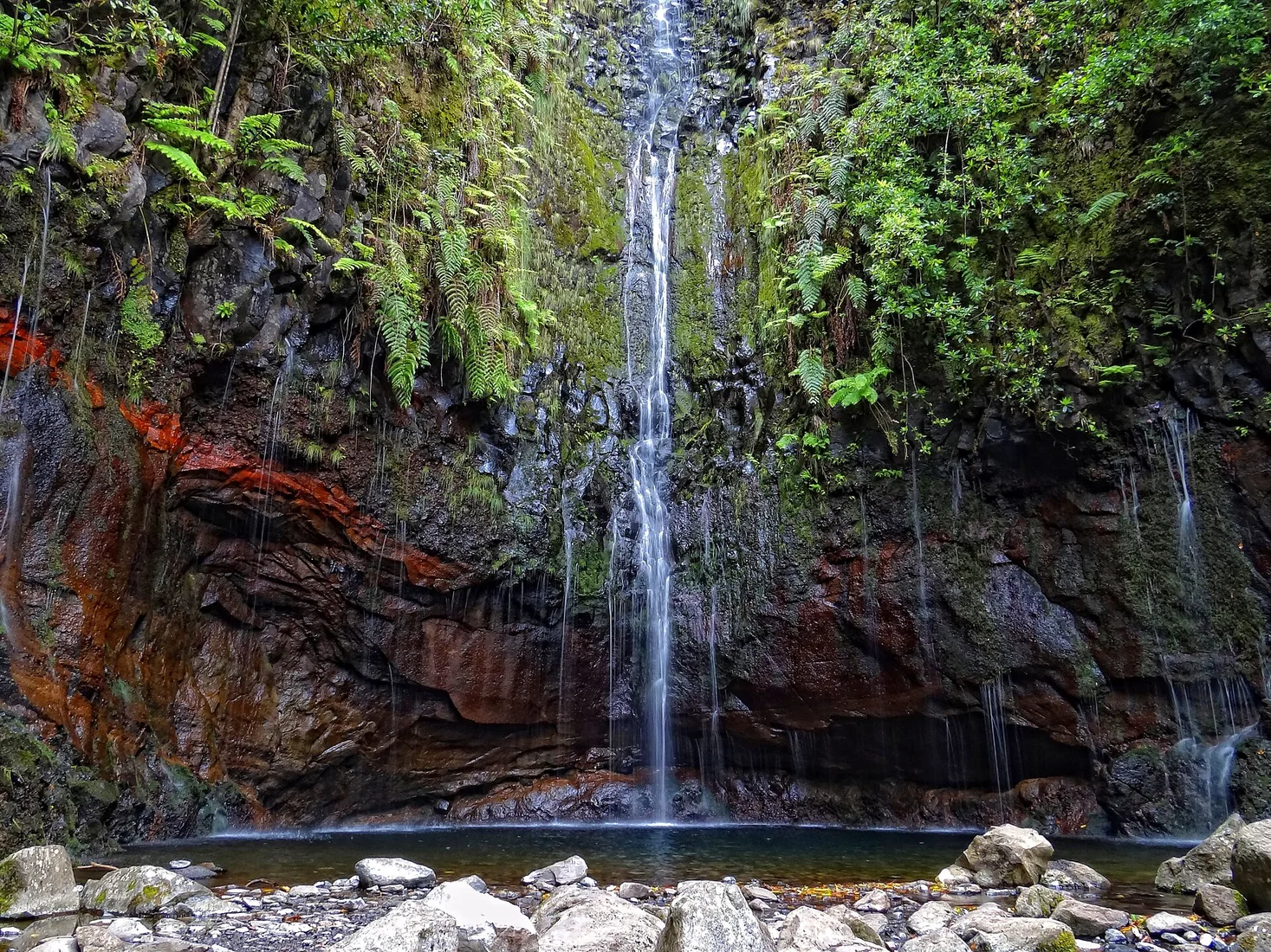 Water threads falling into the green pool at the end of the 25 Fontes levada walk