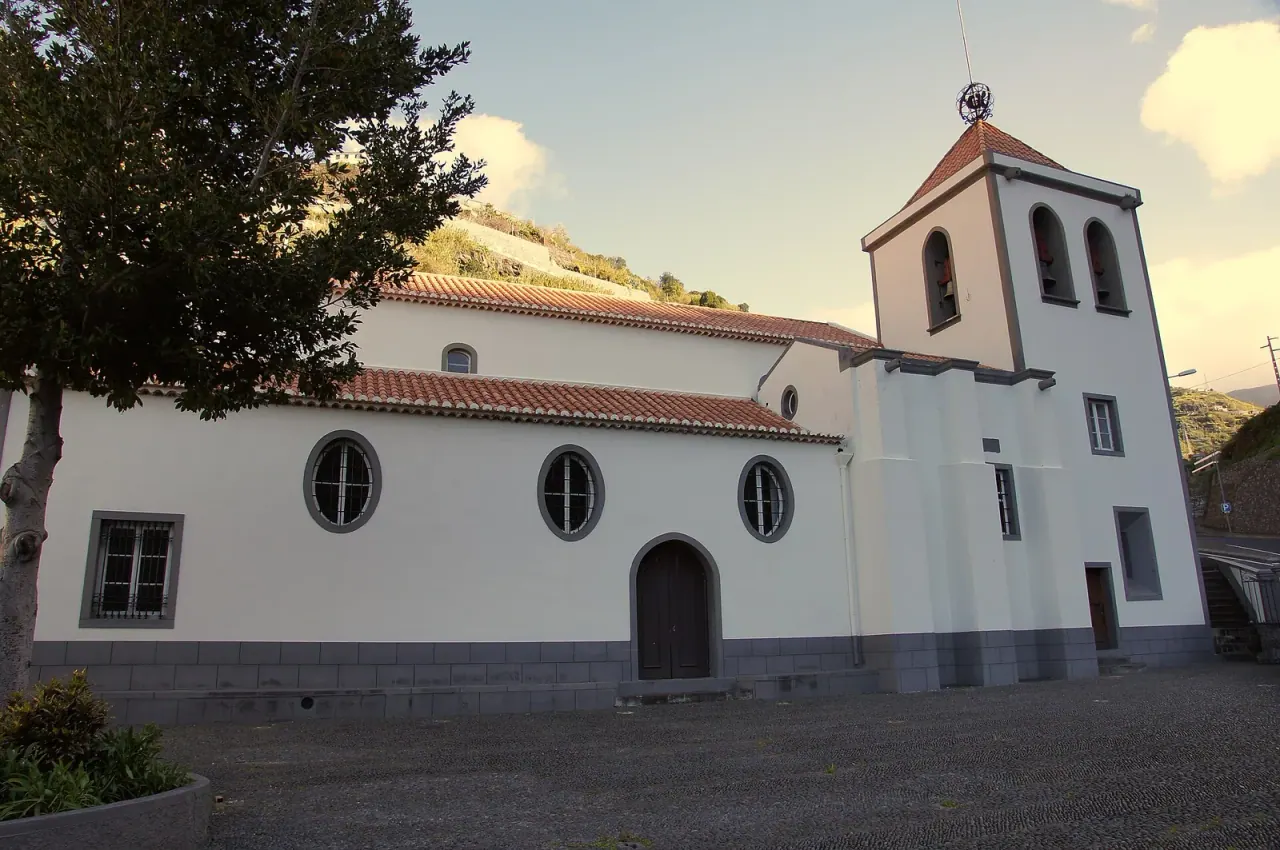 The white façade and basalt trim of the parish church of the Holy Spirit in Calheta
