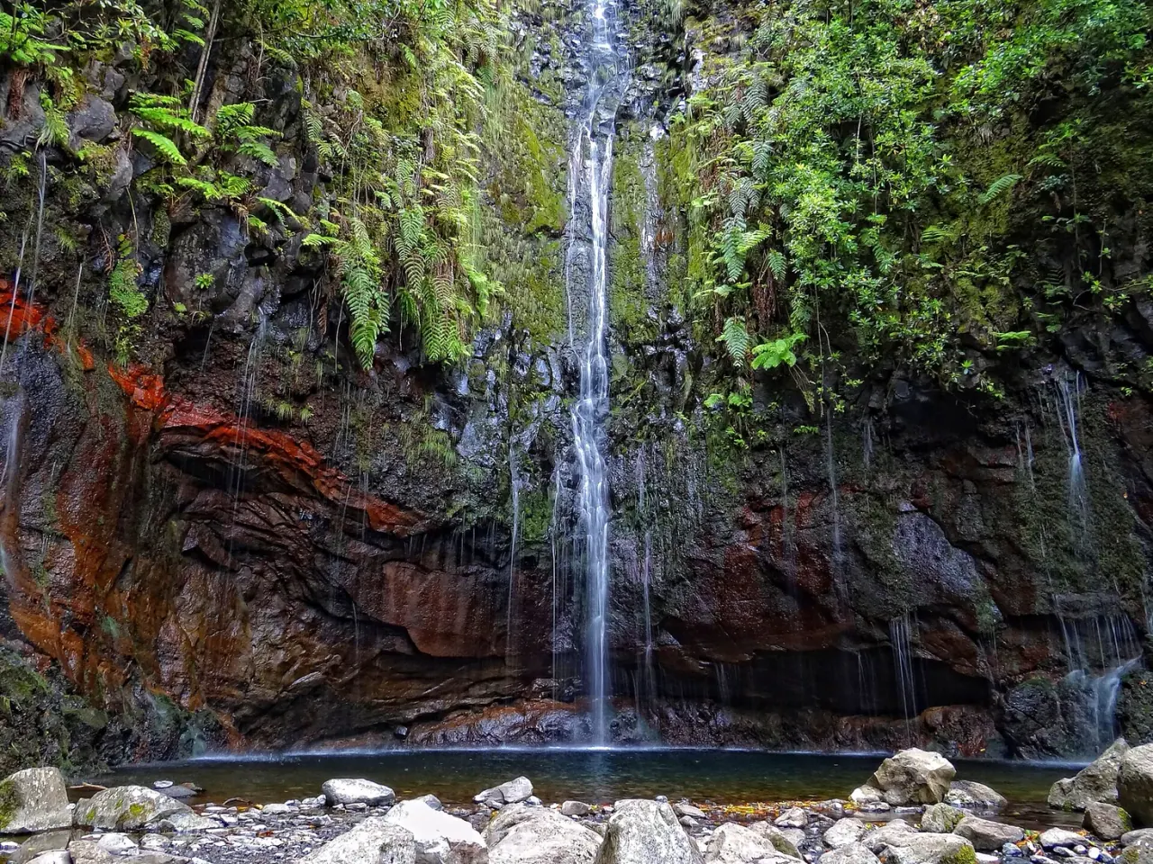 Water threads falling into the green pool at the end of the 25 Fontes levada walk