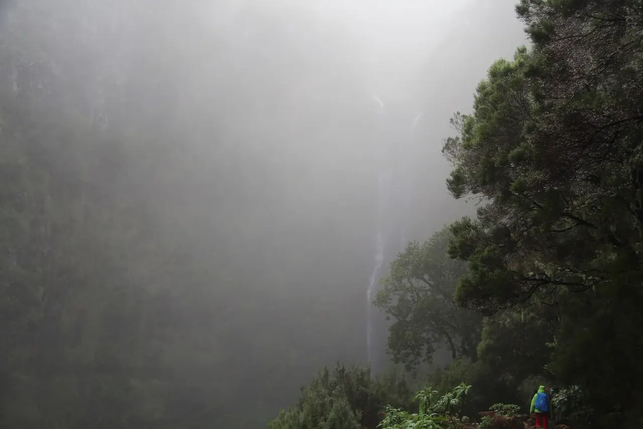 The Risco waterfall dropping through mist on the wall above the Rabaçal valley